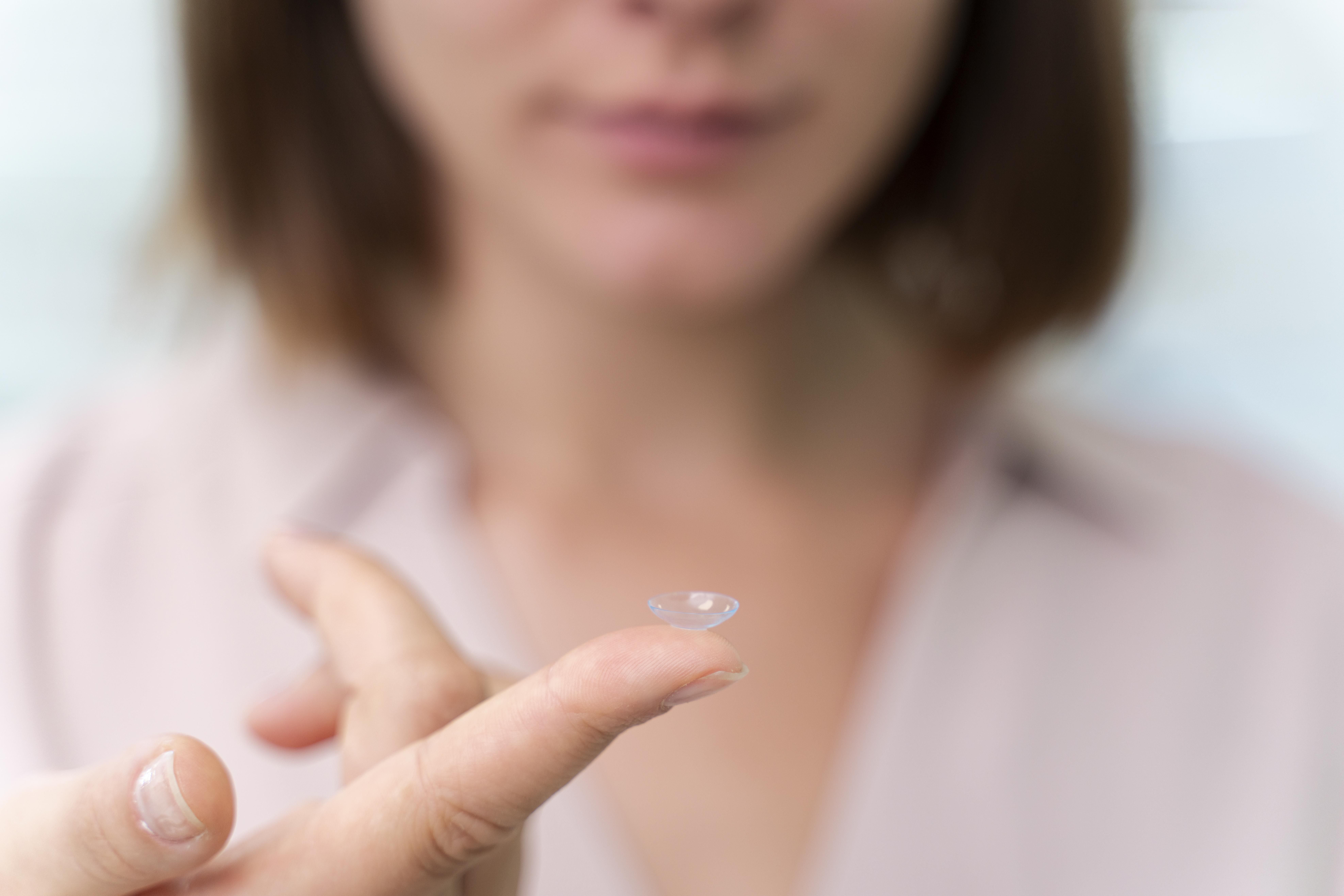 Vrouw controleert nieuwe contactlenzen bij Optiek De Clerck